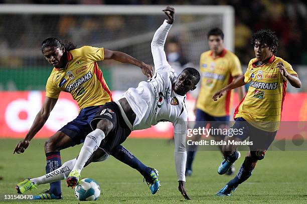 Joel Huigui and Jorge Gastelum of Monarcas Morelia struggles for the ball with Jackson Martinez of Jaguares during a match between Morelia and...