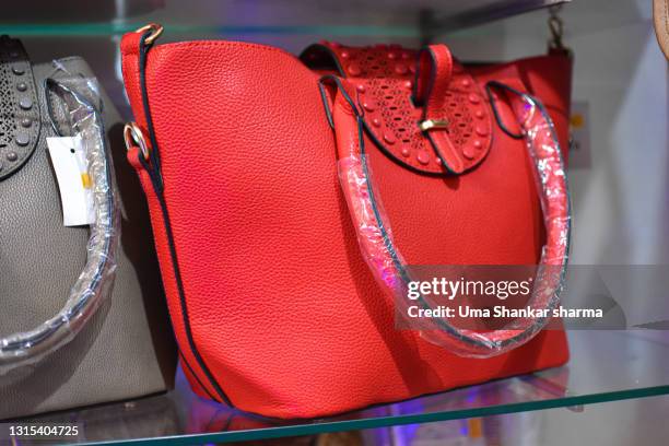 ladies designer red handbag with elegant and sleek design. fashion forward look and fine finish. - designer handbag stockfoto's en -beelden