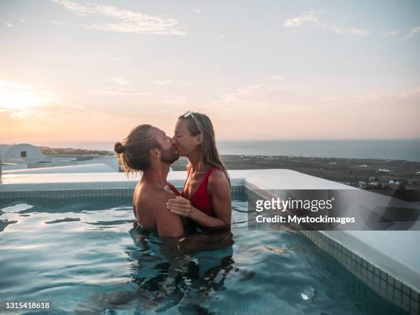 romantic couple kissing at sunset in a hot tub - bathing in sunset stock pictures, royalty-free photos & images