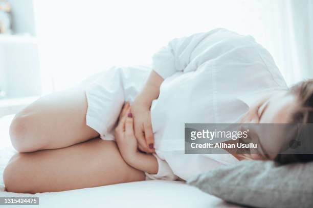 患有月經疼痛的年輕女子抱著肚子 - menstruation 個照片及圖片檔