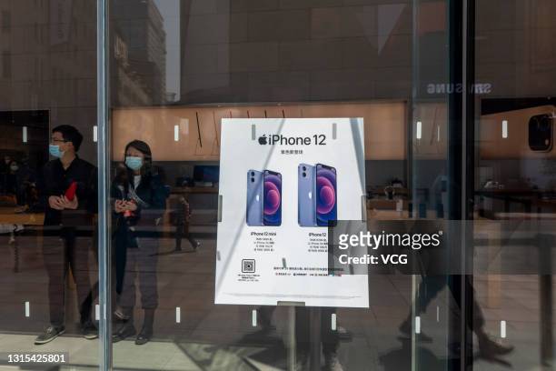 Poster advertising purple iPhone 12 and iPhone 12 mini smartphones is seen at an Apple store on April 30, 2021 in Shanghai, China. The iPhone 12 and...