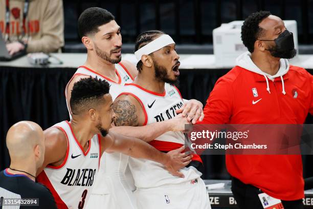 Carmelo Anthony of the Portland Trail Blazers is held back by teammates CJ McCollum and Enes Kanter after Anthony made a three point basket against...