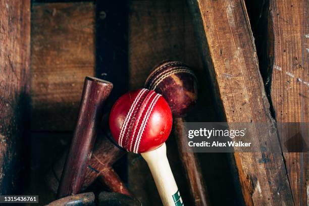 cricket ball on top of bat against wooden wall - cricket bat stock-fotos und bilder