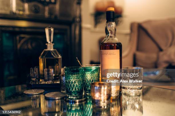 bottle of scotch whisky with various ornate glasses and candles. - scotch whisky stock pictures, royalty-free photos & images