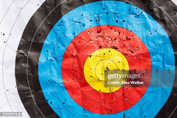 multi-coloured archery target rings with holes - bulls eye stock pictures, royalty-free photos & images