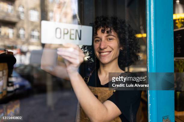 happy non-binary business owner reopening their store - reopening ストックフォトと画像