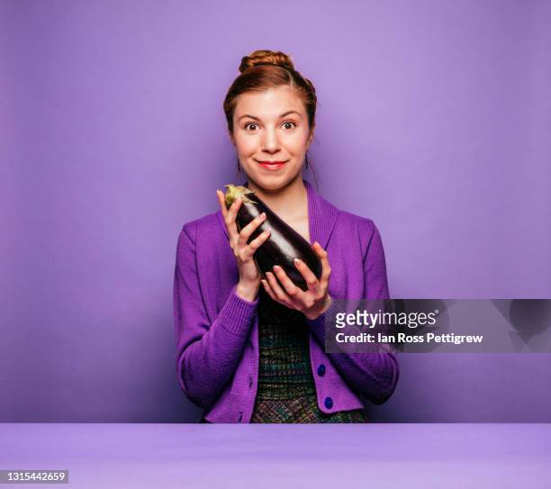 young woman holding an eggplant - eggplant stockfoto's en -beelden