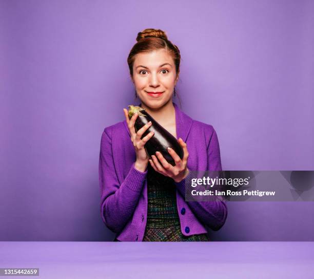 young woman holding an eggplant - aubergine stock pictures, royalty-free photos & images