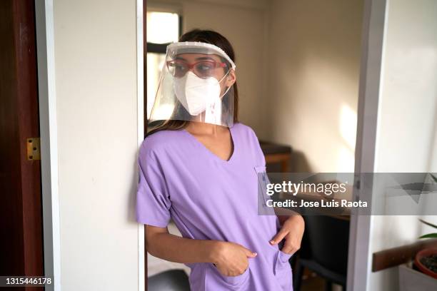 young doctor with protective mask and uniform besides a door. - argentina covid stock pictures, royalty-free photos & images