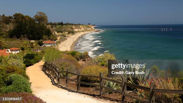 footpath down to public beach on a bright sunny day with unidentifiable beach goers in the distance - santa barbara stock pictures, royalty-free photos & images