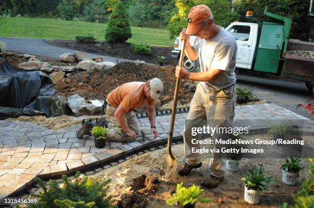 Photo Ryan McFadden Diebolt Landscape is putting in hardscaping and new plants at a Wyomissing home; from left is forman Ryan Evans finishing...