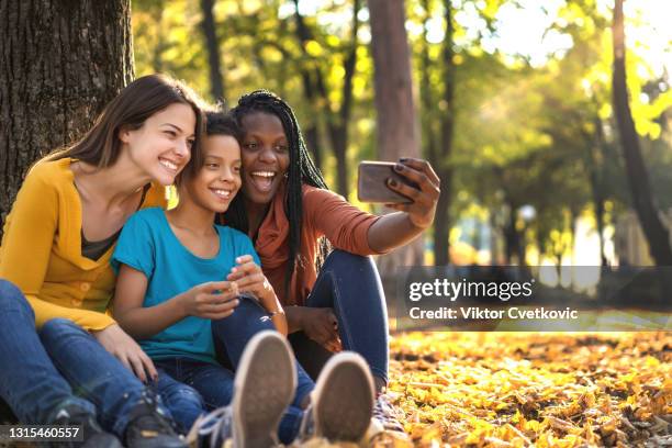 amigos multiétnicos con niños tomándose selfie - teenage lesbian fotografías e imágenes de stock