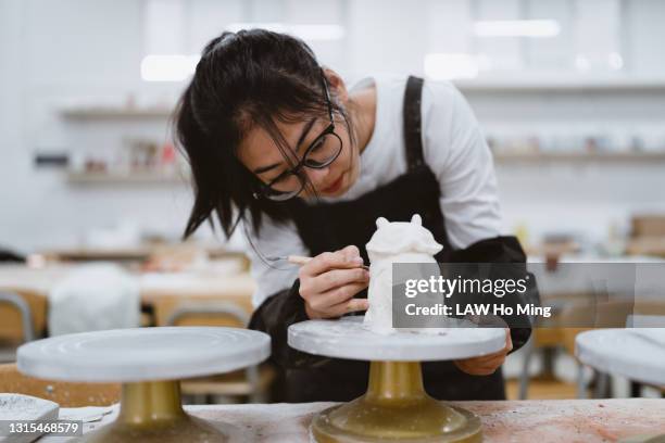 a chinese female student is sculpting in the pottery classroom - sculptor stock pictures, royalty-free photos & images