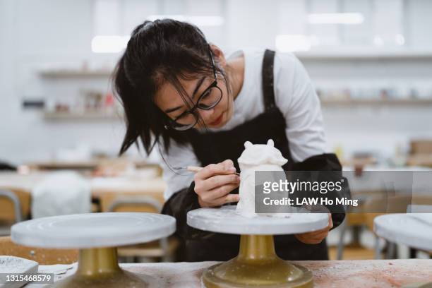 a chinese female student is sculpting in the pottery classroom - carving craft activity bildbanksfoton och bilder
