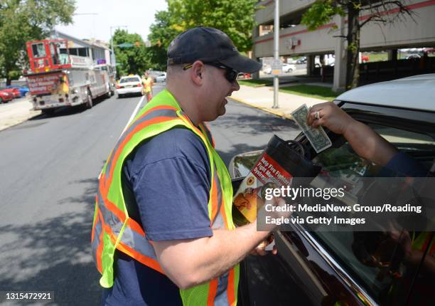 Firefighter Jason Licwinko, with Engine 9, receives a donation from a passing motorist.During the "Fill the Boot" campaign conducted by the Reading...