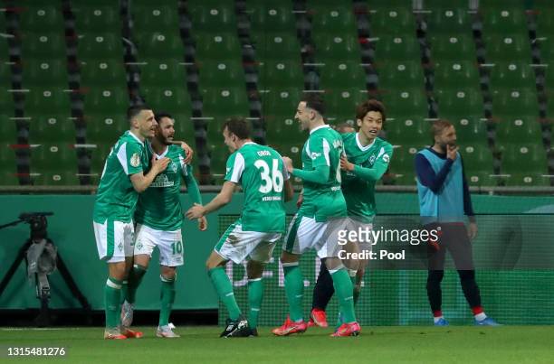 Leonardo Bittencourt of Werder Bremen celebrates with his team mates after scoring his team's first goal during the DFB Cup semi final match between...