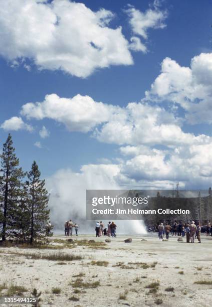 35mm film photo shows people standing around the Daisy Geyser in Yellowstone National Park, 1941.