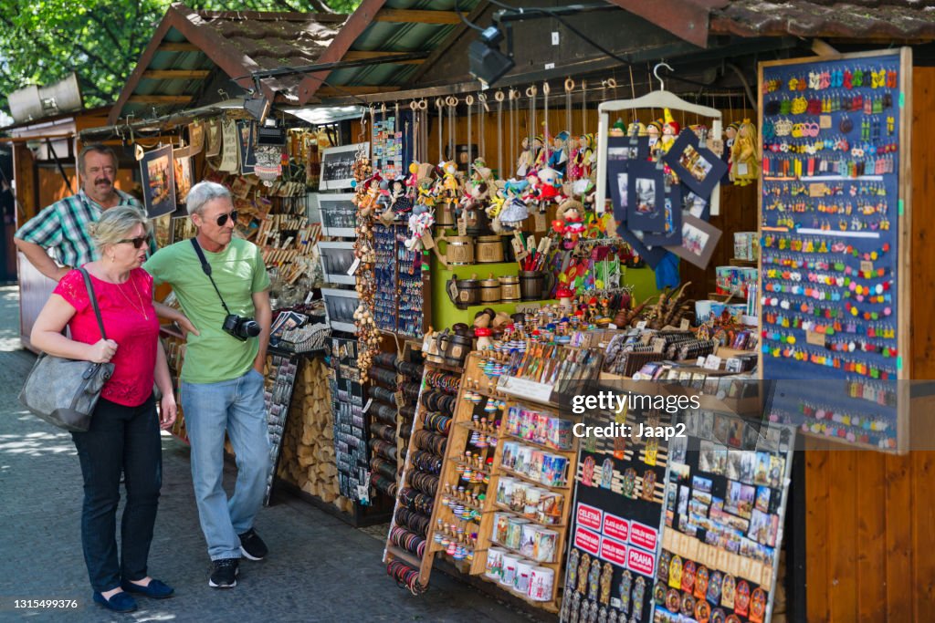 Tourists walking by a souvenir both on the old town square in Prague