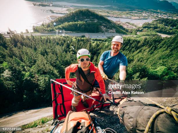 two big wall climbers stand on a portaledge high up on squamish chief - adrenalin stock-fotos und bilder