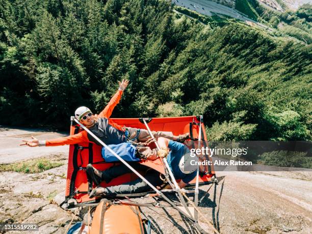 two big wall climbers relax on a portaledge high up on the side of the stawamus chief in squamish - the comedy tent stock pictures, royalty-free photos & images