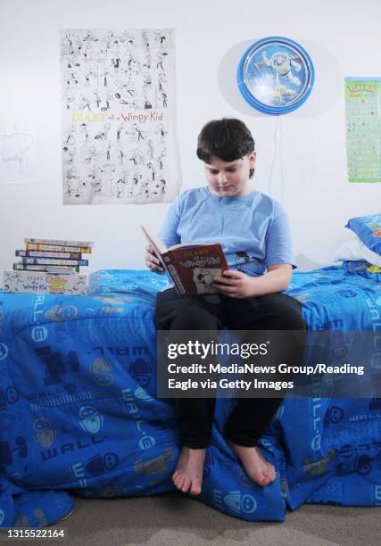 Exeter Township, PA&#10;&#10;Connor McHugh sits on his bed in his Exeter Township home reading one of the "Diary of a Wimpy Kid" books that he owns....