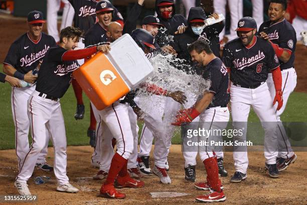 Kyle Schwarber of the Washington Nationals celebrates with teammates after hitting a walk-off home run against the Miami Marlins during the tenth...