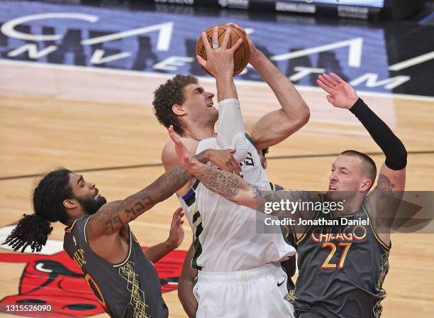 Brook Lopez of the Milwaukee Bucks tries to get off a shot under pressure from Coby White and Daniel Theis of the Chicago Bulls at the United Center...