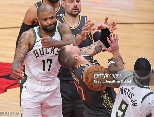 Daniel Theis of the Chicago Bulls looses control of a rebound under pressure from P.J. Tucker and Bobby Portis of the Milwaukee Bucks at the United...