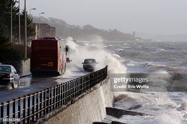 stormy waves crashing over road buses and cars - car splashing stock pictures, royalty-free photos & images