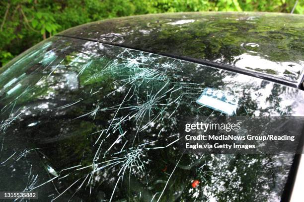 Spider cracks cover a windshield on a car damaged by the hail storm which hit the area Thursday. They are showing up at repair shops such as the...