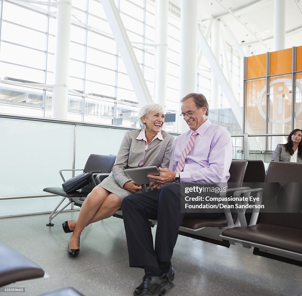 Business people using digital tablet at airport