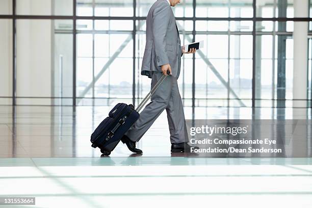 low section of businessman walking at airport - wheeled luggage 個照片及圖片檔