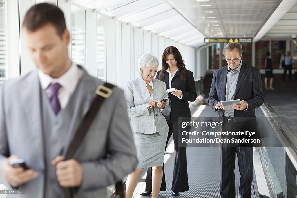 Businesspeople at airport using conveyor belt
