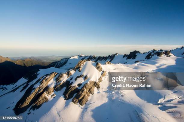 snowcapped glacier mountain peak, viewed from above - franz josef glacier stock-fotos und bilder