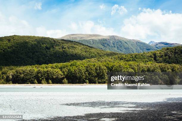 lush green mountains and gravel river bed - berma da estrada imagens e fotografias de stock