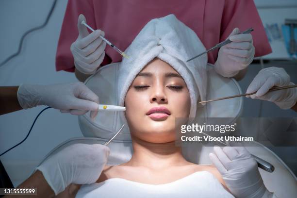 conceptual beauty and cosmetology image of the hands of several beauticians holding their respective equipment. - lip injections stock pictures, royalty-free photos & images