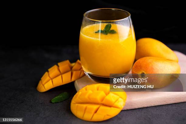 fresh tropical fruit smoothie mango juice on wooden background - mango smoothie stock pictures, royalty-free photos & images