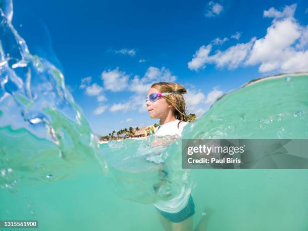 smiling boy swimming in the sea wearing swimming goggles - boy swimming stock pictures, royalty-free photos & images