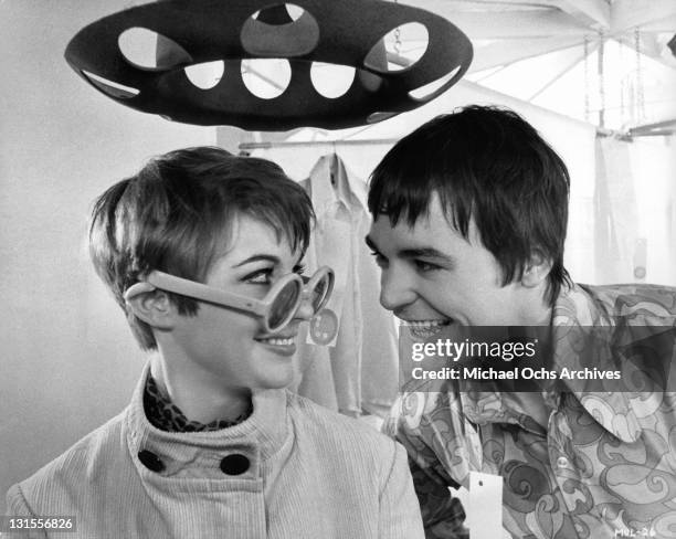 Sun glass wearing Adrienne Posta smiling at Barry Evans in a scene from the film 'Here We Go Round The Mulberry Bush', 1968.