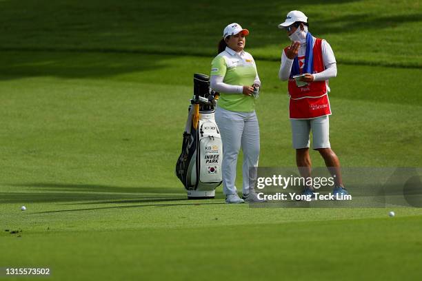 Inbee Park of South Korea speaks with her husband and caddie Gi Hyeob Nam as she waits to play her second shot on the second fairway during the third...