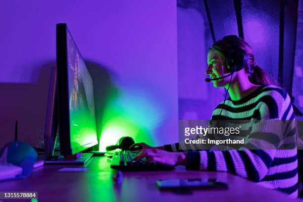 teenager-mädchen spielen multiplayer-online-spiele mit desktop-pc - computerspieler stock-fotos und bilder