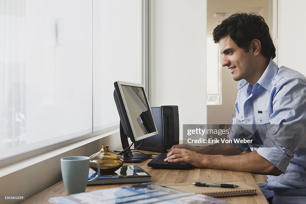 Man with desktop computer in home