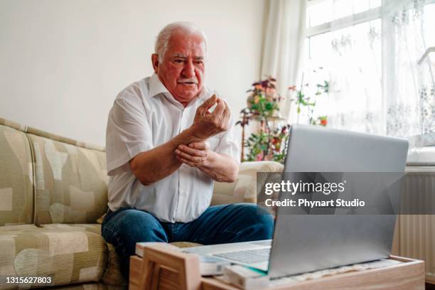 älterer mann hat videoanruf mit arzt zu hause - exercise pill stock-fotos und bilder