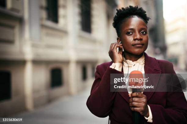 tv reporter presenting the news outdoors. - jornalismo imagens e fotografias de stock