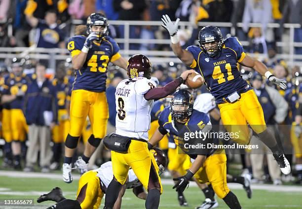 Quarterback Ryan Radcliff of the Central Michigan Chippewas sets up to throw a pass while linebackers Zach Hitchens and C.J. Malauul and defensive...