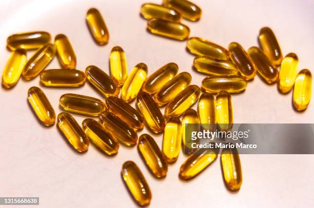 omega-3 capsules - fish oil stock pictures, royalty-free photos & images