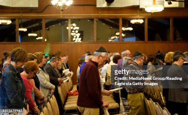 Attendees stand to say a prayer during a memorial service on Tuesday, April 30, 2019 at Chabad-Lubavitch of Berks County for victims of the Poway, CA...