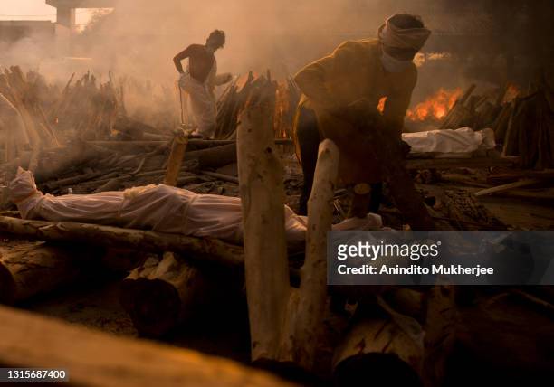 Priest prepares to perform the last rites of a patient who died of COVID-19 during a mass cremation at a crematorium on May 01, 2021 in New Delhi,...