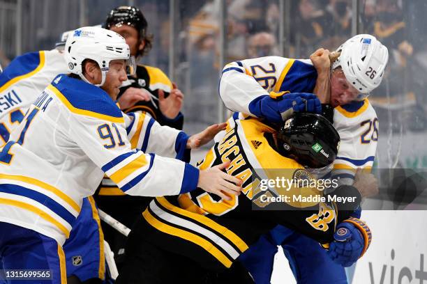 Brad Marchand of the Boston Bruins fights Rasmus Dahlin of the Buffalo Sabres during the third period at TD Garden on May 01, 2021 in Boston,...