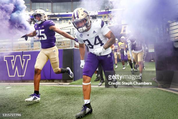 Defensive back Elijah Jackson and running back Capassio Cherry of the Washington Huskies take the field before the spring game at Husky Stadium on...